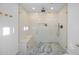 Modern tiled shower with glass enclosure, built-in bench, and rainfall showerhead in a luxurious bathroom at 1818 W Highland Ave, Phoenix, AZ 85015
