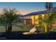 Charming home exterior featuring a manicured lawn, palm trees, and illuminated landscaping rocks at 1818 W Highland Ave, Phoenix, AZ 85015