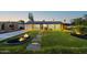 Charming single-story home featuring a manicured lawn, brick walkway, and inviting exterior lighting at 1818 W Highland Ave, Phoenix, AZ 85015