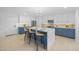 Modern kitchen with an island, white cabinets, and marble countertops, illuminated by a contemporary chandelier at 1818 W Highland Ave, Phoenix, AZ 85015