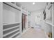 Spacious walk-in closet with custom shelving and racks and views to the ensuite bathroom at 1818 W Highland Ave, Phoenix, AZ 85015