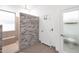 Bright bathroom featuring a walk-in shower with stone accent wall and gray tile surround at 18455 W San Carlos Dr, Goodyear, AZ 85338