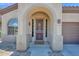 Charming front entrance with arched doorway, security door, and a 'HELLO' welcome mat at 18455 W San Carlos Dr, Goodyear, AZ 85338