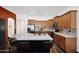 A kitchen featuring an island, stone countertops, stainless steel appliances and wooden cabinetry at 18455 W San Carlos Dr, Goodyear, AZ 85338