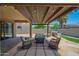 Inviting covered patio featuring comfortable seating, built-in BBQ, and stylish stone flooring, perfect for outdoor entertaining at 18455 W San Carlos Dr, Goodyear, AZ 85338