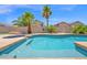 Sparkling pool with baja shelf, surrounded by lush landscaping and privacy walls, creating a serene outdoor retreat at 18455 W San Carlos Dr, Goodyear, AZ 85338