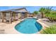 Inviting pool area with a baja shelf, covered cabana, lush landscaping, creating a perfect backyard retreat at 18455 W San Carlos Dr, Goodyear, AZ 85338