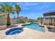 Sparkling pool and spa area with lush landscaping, palm trees, and a shaded lounge area for ultimate relaxation at 18455 W San Carlos Dr, Goodyear, AZ 85338