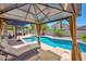 Relaxing backyard oasis with covered patio, lounge chairs, and a sparkling swimming pool for hot summer days at 18455 W San Carlos Dr, Goodyear, AZ 85338