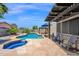 Beautiful backyard with a pool, spa, shaded lounge, and outdoor seating, perfect for enjoying sunny days at 18455 W San Carlos Dr, Goodyear, AZ 85338