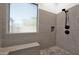 Modern shower showcasing gray tiled walls, bench seating, rain shower head and unique mosaic tile flooring at 18455 W San Carlos Dr, Goodyear, AZ 85338
