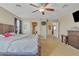 Spacious primary bedroom featuring a ceiling fan, en-suite bathroom, and neutral decor at 1923 N Cocoa Ct, Casa Grande, AZ 85122