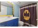 Stylish bathroom features a blue vanity, yellow accents, and a Batman-themed shower curtain at 1927 E Hampton Ave # 204, Mesa, AZ 85204
