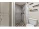 Bathroom featuring a tiled walk-in shower with decorative pebble base and a convenient linen cabinet at 1927 E Hampton Ave # 204, Mesa, AZ 85204