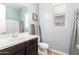 Bright bathroom with white sink, dark wood cabinets, and a framed mirror at 20563 W Edgemont Ave, Buckeye, AZ 85396