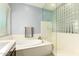 Bathroom featuring a soaking tub and a clear glass shower door for modern appeal at 20563 W Edgemont Ave, Buckeye, AZ 85396