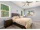 Cozy bedroom featuring a ceiling fan, neutral walls, and plenty of natural light from the large windows at 20563 W Edgemont Ave, Buckeye, AZ 85396