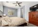 Bright bedroom with a ceiling fan, and a large wood dresser for plenty of storage at 20563 W Edgemont Ave, Buckeye, AZ 85396
