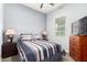 Cozy bedroom features a striped bedspread and light blue walls, creating a peaceful and inviting atmosphere at 20563 W Edgemont Ave, Buckeye, AZ 85396