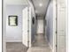 Bright hallway with wood-look tile, neutral paint, and white doors at 20563 W Edgemont Ave, Buckeye, AZ 85396