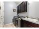 Functional laundry room with modern washer and dryer, sink, and ample cabinet space at 20563 W Edgemont Ave, Buckeye, AZ 85396