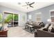 Comfortable living room with tile floors, neutral walls, ceiling fan, and sliding glass doors to the back patio at 20563 W Edgemont Ave, Buckeye, AZ 85396