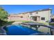 Private backyard oasis with a sparkling pool, lush green lawn, and desert landscaping for outdoor enjoyment at 20722 N 38Th St, Phoenix, AZ 85050