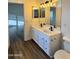 Bathroom with dual sink vanity, modern fixtures, wood-look floors, and updated lighting at 20722 N 38Th St, Phoenix, AZ 85050