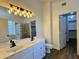 Bathroom with dual sink vanity, modern fixtures, wood-look floors, and glass block shower/tub enclosure at 20722 N 38Th St, Phoenix, AZ 85050