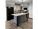 Updated kitchen with white cabinets, gray island, mosaic backsplash, stainless steel appliances, and wood floors at 20722 N 38Th St, Phoenix, AZ 85050