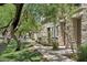 Landscaped walkway with mature trees leading to a stone-clad townhome facade at 2313 E Hidalgo Ave, Phoenix, AZ 85040