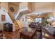 Warm living room featuring hardwood floors, a staircase, and comfortable leather furnishings at 2524 S El Paradiso -- # 17, Mesa, AZ 85202