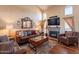 Cozy living room with comfortable leather seating, a stone fireplace, a wall-mounted TV, and plentiful natural light at 2524 S El Paradiso -- # 17, Mesa, AZ 85202