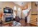 Bright living room featuring a fireplace, staircase, wood flooring, and high ceilings for an open and airy ambiance at 2524 S El Paradiso -- # 17, Mesa, AZ 85202