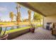 Relaxing patio with brick flooring overlooking lush green space and a tranquil canal at 2524 S El Paradiso -- # 17, Mesa, AZ 85202