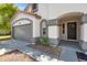 Close up of single story home with gray garage door, arched entryway and meticulous landscaping at 3220 W Frankfurt Dr, Chandler, AZ 85226