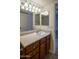 Bathroom vanity features wood cabinets, white countertop, and large mirror at 3330 W Danbury Dr # E203, Phoenix, AZ 85053