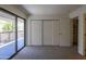 Bedroom features plush carpet, closet, and sliding glass door to balcony at 3330 W Danbury Dr # E203, Phoenix, AZ 85053