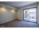 Bedroom features plush carpet, recessed lighting, and sliding glass door to balcony at 3330 W Danbury Dr # E203, Phoenix, AZ 85053