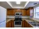Bright kitchen with stainless steel appliances and wooden cabinets with stylish countertops at 3330 W Danbury Dr # E203, Phoenix, AZ 85053
