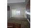 View of a spacious living room with plush carpet and a sliding glass door to a balcony, seen from the kitchen at 3330 W Danbury Dr # E203, Phoenix, AZ 85053