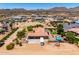 Wide aerial shot showcases a desert property with a pool, lush landscaping, and ample parking at 3614 W Phillips Rd, San Tan Valley, AZ 85144