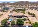 Aerial perspective of desert house with a private backyard pool, lush garden, and extended patio at 3614 W Phillips Rd, San Tan Valley, AZ 85144