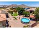 Lush backyard features a pool, lawn, mature trees, patio, playset, and lovely mountain views at 3614 W Phillips Rd, San Tan Valley, AZ 85144