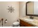 Powder room with a wood vanity, granite countertop, and decorative mirror at 3614 W Phillips Rd, San Tan Valley, AZ 85144