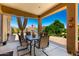 Covered patio showcases outdoor dining set, overhead lighting, and views of the well-maintained backyard and landscape at 3614 W Phillips Rd, San Tan Valley, AZ 85144