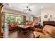 Spacious living room boasts a leather sectional, dark wood floors, and sliding glass doors to the outdoor patio at 3614 W Phillips Rd, San Tan Valley, AZ 85144