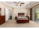 This main bedroom has neutral paint, carpet, fan, tray ceiling, and sliding glass door with access to an outdoor patio at 3614 W Phillips Rd, San Tan Valley, AZ 85144