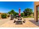 Backyard patio features an outdoor picnic table and grill with lush landscaping and bright blue sky views at 3614 W Phillips Rd, San Tan Valley, AZ 85144