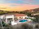 Enjoy Arizona sunsets in this beautiful home with a sparkling pool, spa, and lush green landscaping in a desert landscape at 3946 N Pinnacle Hills Cir, Mesa, AZ 85207